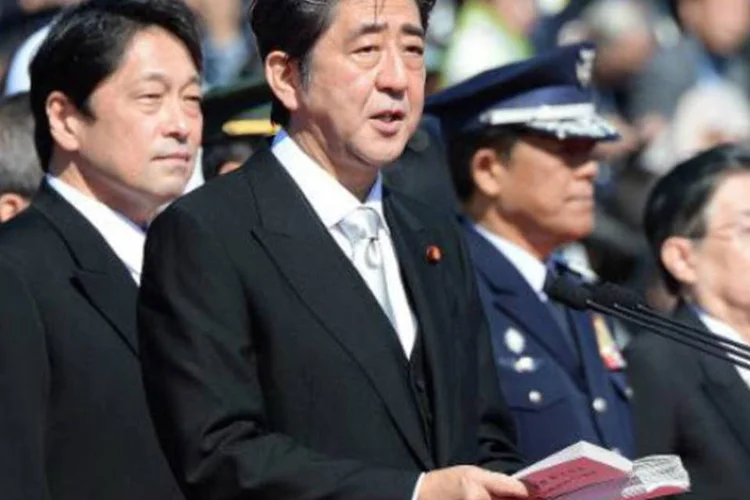 O primeiro-ministro do Japão, Shinzo Abe (C), discursa diante do ministro da Defesa, Itsunori Onodera (E): suspeita-se que há reservas de petróleo na área (Toru Yamanaka/AFP)