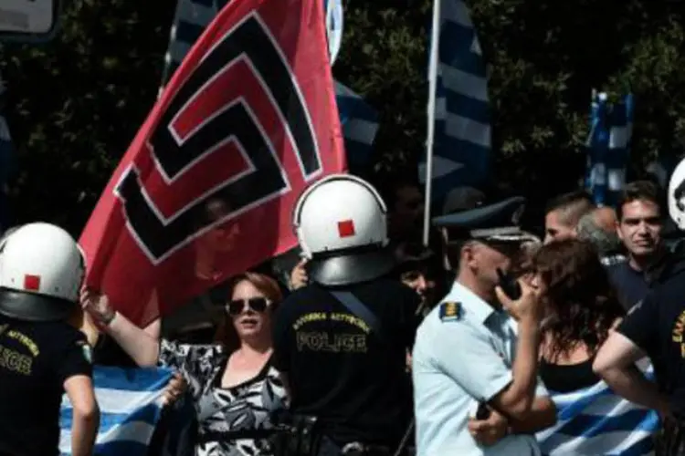 Simpatizantes do Aurora Dourada carregam bandeira do partido: medida é parte da ofensiva das autoridades contra o partido neonazista (Aris Messinis/AFP)