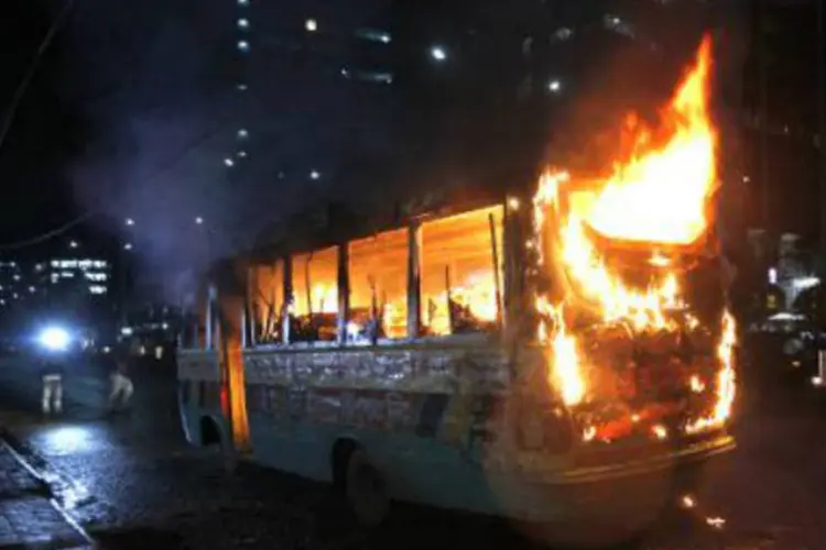 
	&Ocirc;nibus incendiado por manifestantes em Bangladesh:&nbsp;ao longo desta segunda-feira, tr&ecirc;s carros e quatro &ocirc;nibus foram incendiados
 (AFP)