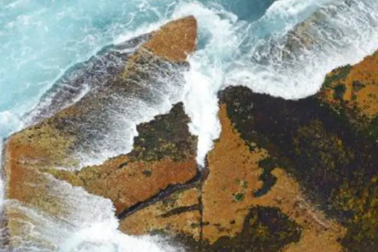 
	Ondas batem em rochas: o Jap&atilde;o se encontra a uma dist&acirc;ncia de 17 mil quil&ocirc;metros do Chile
 (Greg Wood/AFP)