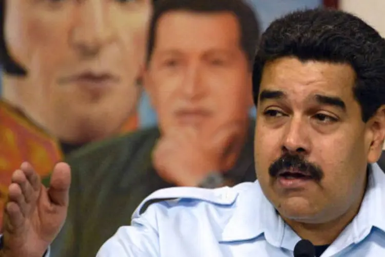 
	Nicol&aacute;s Maduro com pintura de Ch&aacute;vez e Sim&oacute;n Bol&iacute;var: &quot;Um ano que partiu desta vida, e nos deixou toda esta esperan&ccedil;a. &Eacute; esta grande causa que hoje defendemos&quot;
 (AFP/Getty Images)