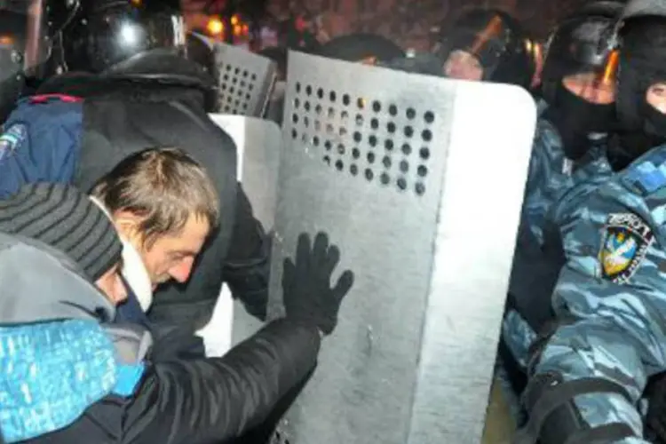 
	Manifestantes enfrentam a pol&iacute;cia na Ucr&acirc;nia: &quot;esperamos uma decidida condena&ccedil;&atilde;o &agrave;s a&ccedil;&otilde;es ilegais das for&ccedil;as radicais&quot;, disse ministro ucraniano
 (Viktor Drachev/AFP)