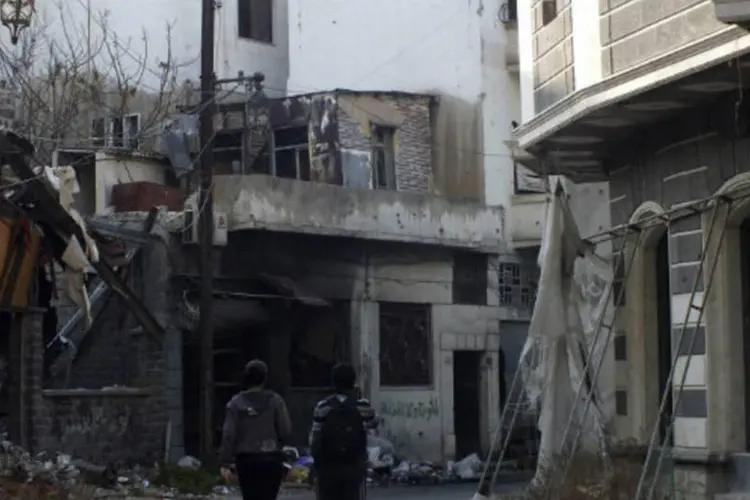 
	Pessoas caminham por &aacute;rea destru&iacute;da na S&iacute;ria:&nbsp;ataques tamb&eacute;m causaram a destrui&ccedil;&atilde;o de diversas casas
 (Yazan Homsy/Reuters)