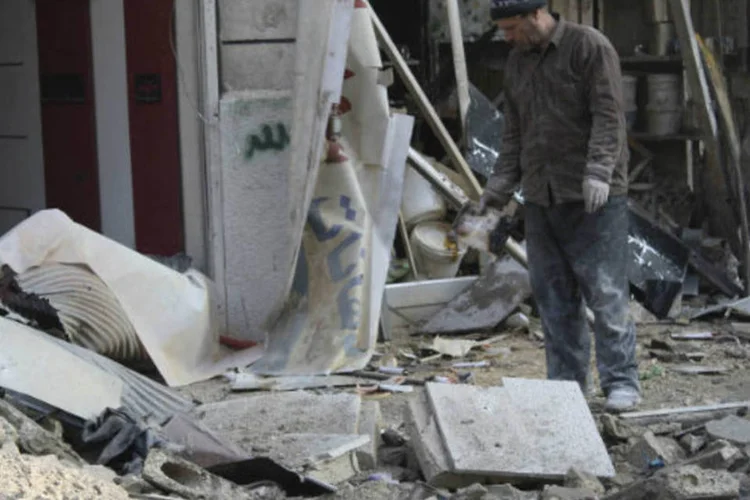 
	Homem em &aacute;rea destru&iacute;da por ataque em Alepo: durante os &uacute;ltimos meses, foram frequentes choques nos arredores da pris&atilde;o entre as for&ccedil;as do regime e os opositores
 (Hosam Katan/Reuters)