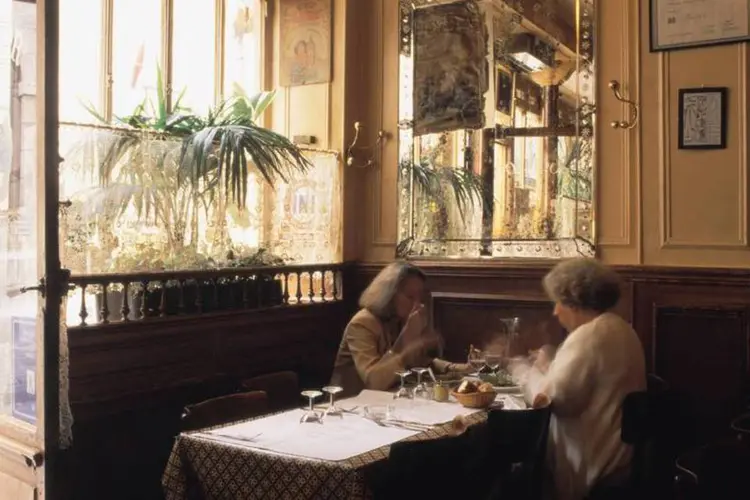 Duas mulheres comendo em um restaurante de Paris, na França (Luis Davilla/Cover/Getty Images)