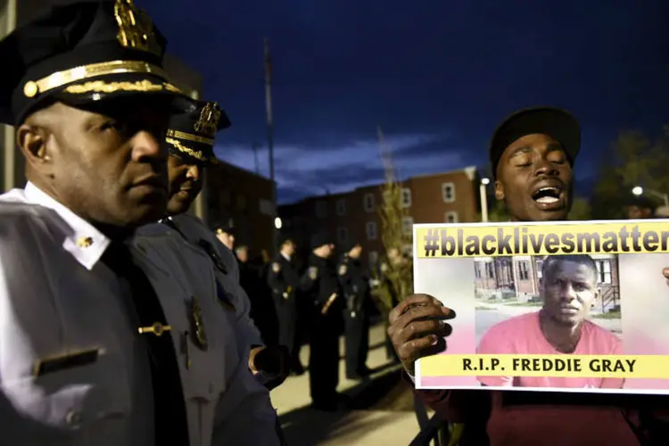 Manifestante segura cartaz em homenagem a Freddie Grey: Gray, de 25 anos, sofreu uma lesão grave enquanto sob custódia policial. Estava em coma até a noite do último domingo, mas não resistiu (Reuters)