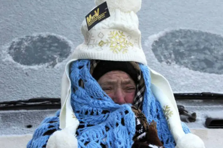 Vendedor tenta suportar o frio enquanto trabalha nas ruas de Moscou: desde o início da onda de frio, 371 pessoas foram hospitalizadas e 56 morreram
 (Viktor Drachev/AFP)