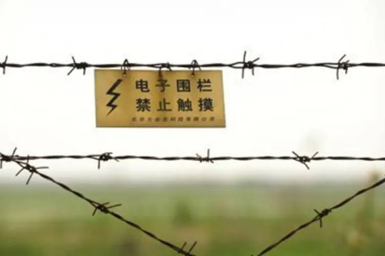 
	Cerca de arame farpado na fronteira entre China e Coreia do Norte: a maioria das pessoas que passa pela fronteira &eacute; formada por empres&aacute;rios chineses ou norte-coreanos
 (Peter Parks/AFP)