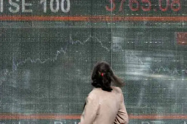 Mulher olha painel com movimento do índice FTSE 100, da bolsa de Londres, em outubro de 2008 (Lionel Healing/Stringer)