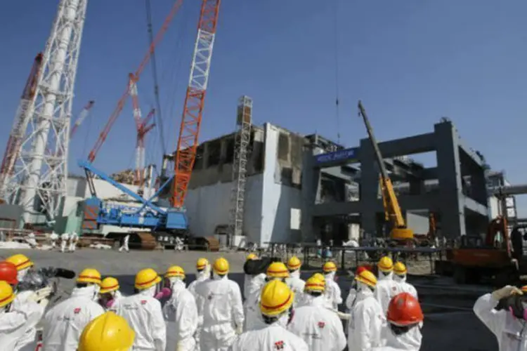 Jornalistas escoltados por funcionários da TEPCO visitam a central nuclear de Fukushima no dia 6 de março de 2013 (AFP / Issei Kato)