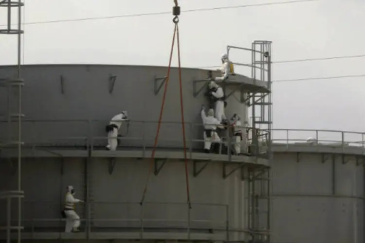 
	Funcion&aacute;rios na usina nuclear de Fukushima, no Jap&atilde;o:&nbsp;a &aacute;gua contaminada, que se acumula em cerca de mil tanques dispostos ao longo de todo o complexo nuclear, aumenta diariamente pelas cerca de 400 toneladas de &aacute;gua subterr&acirc;nea.
 (REUTERS/Issei Kato)