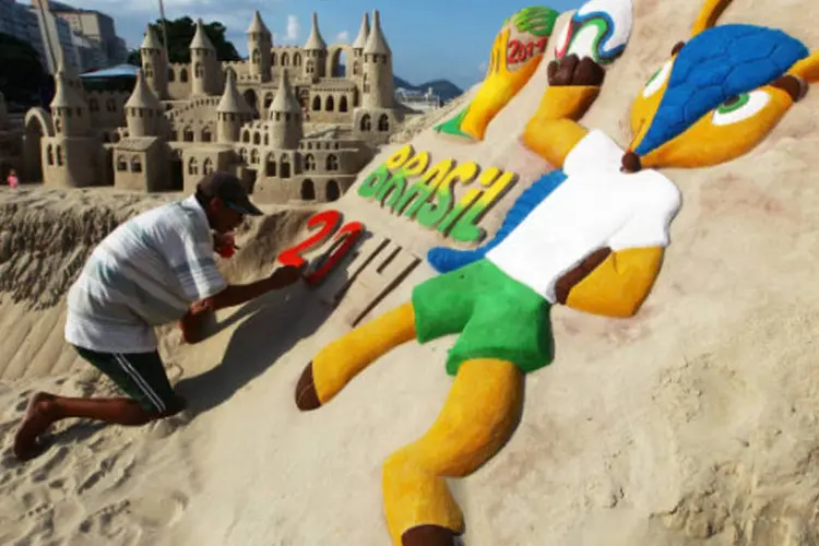 
	Artista desenha mascote da Copa, Fuleco, na areia de Copacabana
 (Mario Tama/Getty Images))