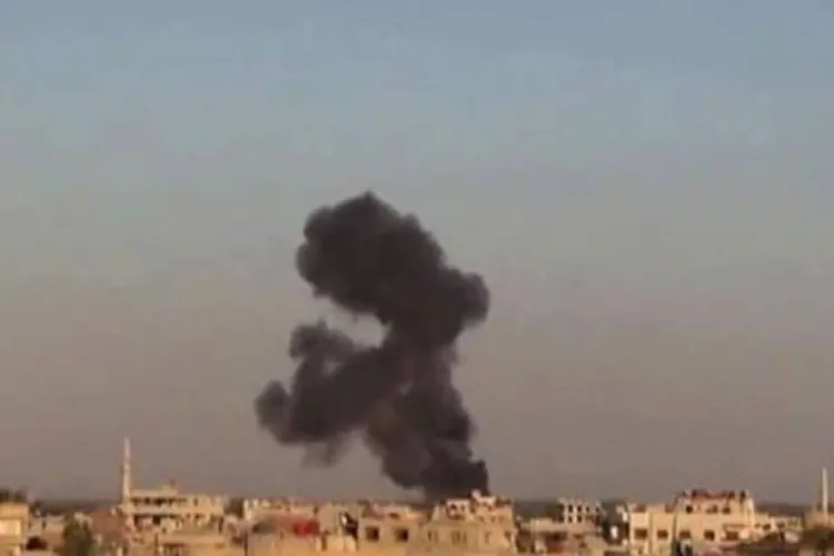 Fumaça é vista no local onde rebeldes sírios derrubaram um helicóptero do exército no subúrbio a leste de Damasco
 (AFP)