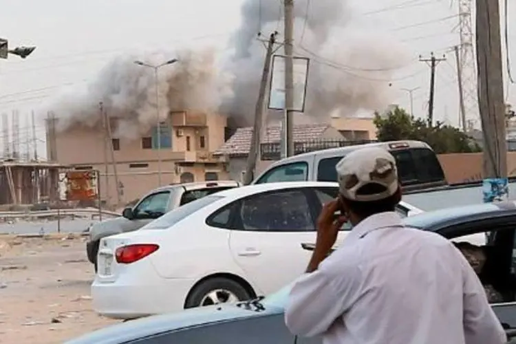 Coluna de fumaça é vista durante confrontos entre milícias em Trípoli, Líbia (Mahmud Turkia/AFP)