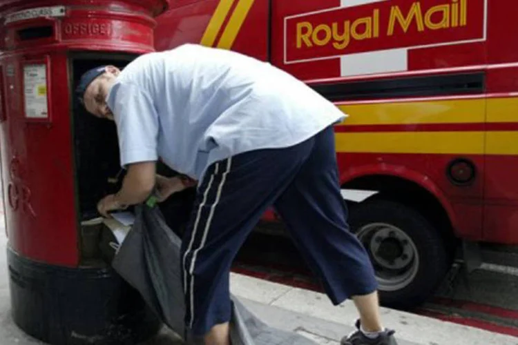Carteiro da Royal mail coleta cartas em Londres: segundo a empresa, seus carteiros sofreram desde abril mais de 3.000 ataques (©AFP / Alessandro Abbonizio)