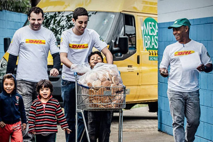 Funcionarios da DHL Express na entrega de pães em uma casa de apoio no complexo do Canindé, em São Paulo: diariamente, dois voluntários 
da empresa, além do motorista, praticam essa ação na capital paulista
 (Fabiano Accorsi)