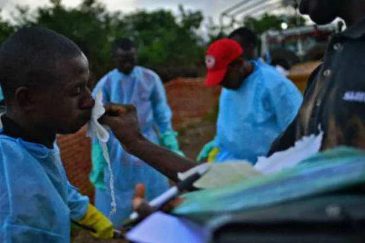 Funcionários são desinfectados: epidemia no oeste da África deixou 1.145 mortos (AFP)