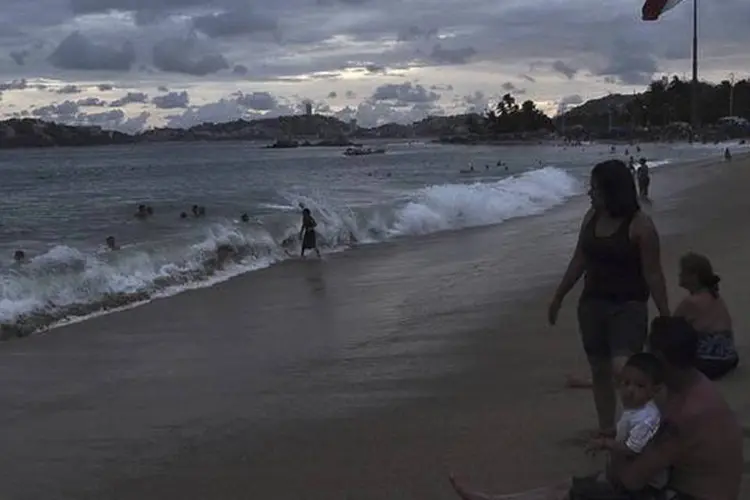 Banhistas aproveitam praia em Acapulco, no México, enquanto o Furacão Odile se afasta da costa noroeste do país (Claudio Vargas/Reuters)
