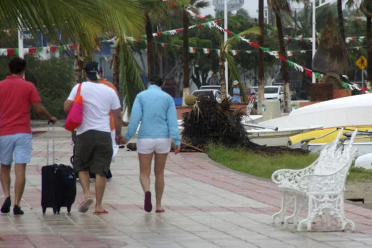 Turistas passam pela destruição deixada pelo furação Odile, que atingiu La Paz, na Baixa Califórnia (Alejandro Acuna/Reuters)