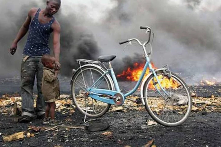 
	Homem com crian&ccedil;a em Agbogbloshie, Gana
 (Blacksmith Institute)