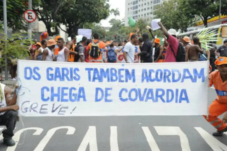 Garis seguram cartaz em manifestação no Rio de Janeiro: alguns bairros da capital fluminense estão tomados de lixo (Tomaz Silva/ABr)