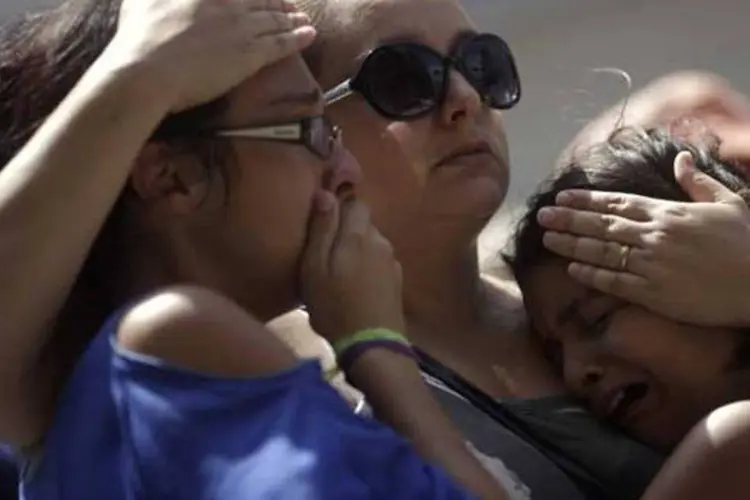 
	Garotas choram perto da boate Kiss, em Santa Maria, Rio Grande do Sul: n&uacute;mero de mortos, que &eacute; de 235 pessoas, ainda pode aumentar
 (REUTERS/Ricardo Moraes)