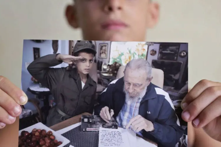 Marlon Mendez, de oito anos, admirador de Fidel Castro, exibe foto de encontro com o ex-líder cubano (Enrique De La Osa/Reuters)