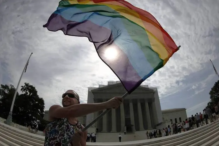 Apoiador do casamento gay agita bandeira com arco-íris em frente à Suprema Corte dos Estados Unidos (REUTERS / Jonathan Ernst)