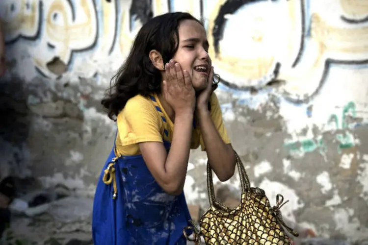 Uma menina palestina se desespera ao ver uma cena de explosão que matou oto crianças e dois adultos na Cidade de Gaza. (28/7/2014)
 (REUTERS/Finbarr OReilly)