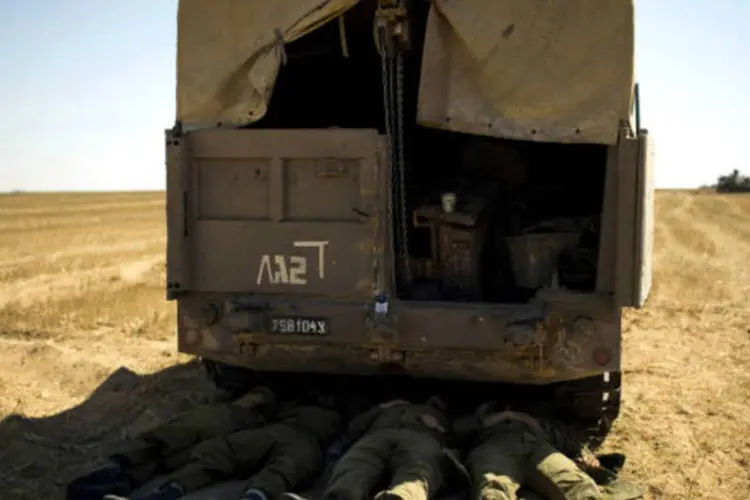  Soldados israelenses se protegem do Sol e dormem embaixo de um caminhão na Faixa de Gaza. (9/7/2014)
 (REUTERS/Amir Cohen)