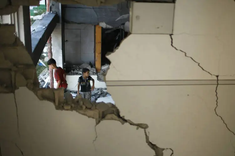 
	Garotos palestinos s&atilde;o vistos entre os escombros de uma mesquita atacada por bombardeios israelenses
 (REUTERS/Mohammed Salem)