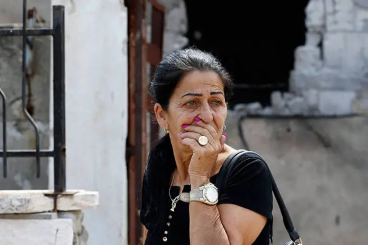 Mulher se assusta ao passar por casa destruída por foguete israelense em Gaza (REUTERS/Baz Ratner)