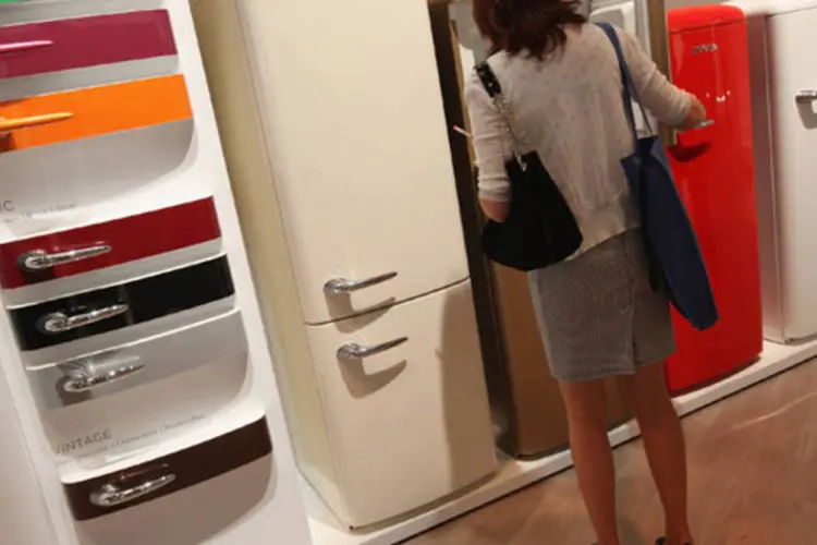 
	Cliente observa geladeira: Antes de financiar o bem &eacute; importante comparar os juros
 (Sean Gallup/Getty Images)