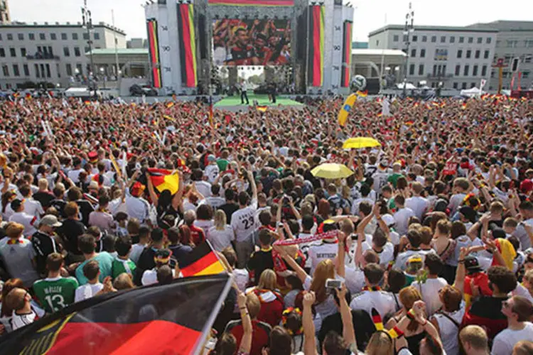 Torcedores alemães comemoram enquanto aguardam próximo ao Portão de Brandenburg, em Berlim, a chegada do time que venceu a Copa do Mundo 2014 (REUTERS/Thomas Peter)
