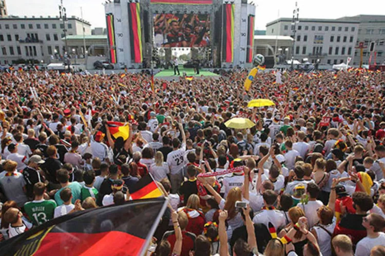 Torcedores alemães comemoram enquanto aguardam próximo ao Portão de Brandenburg, em Berlim, a chegada do time que venceu a Copa do Mundo 2014 (REUTERS/Thomas Peter)