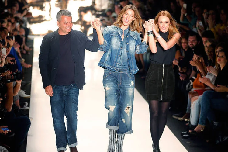 Gisele Bündchen comemora na passarela ao lado dos estilistas Adriana Zucco (d) e Jeziel Moraes (e) no final do desfile da Colcci no SP Fashion Week (REUTERS/Paulo Whitaker)