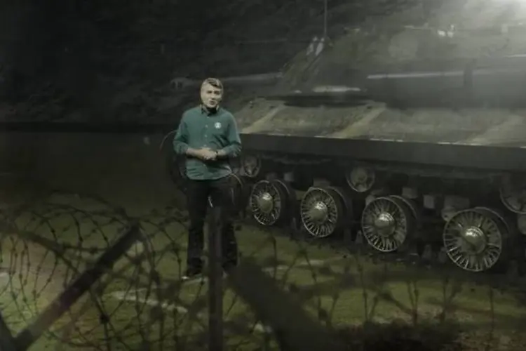 
	Em um momento um tanque de guerra passa ao lado de Cl&eacute;ber Machado
 (Reprodução/YouTube)