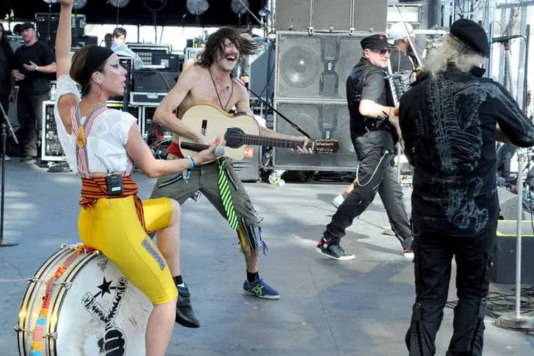 O Gogol Bordelo em ação, com o vocalista Eugene Hutz sem camisa no centro (Getty Images/Kevin Winter)