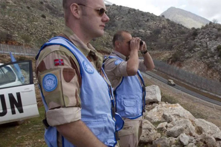 
	Soldados da ONU observam a linha de cessar-fogo entre as Colinas de Gol&atilde; e a S&iacute;ria: Israel ocupou a Colinas de Gol&atilde; em 1967 e anexou esse territ&oacute;rio em 1981
 (AFP/Jack Guez)