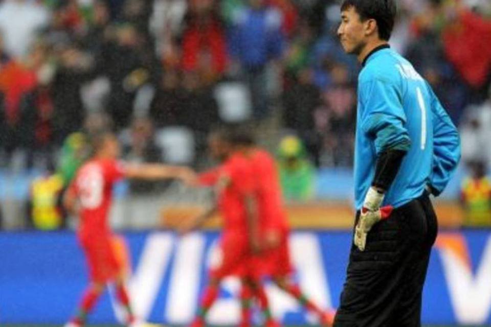 O goleiro Ri Myong-Guk, da Coreia do Norte, observa a comemoração dos jogadores portugueses (.)