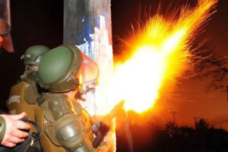 
	Policiais enfrentam manifestantes nas ruas de Santiago em 11 de setembro de 2012: o dia de viol&ecirc;ncia, habitual nesta data, deixou outros 16 policiais feridos
 (Ariel Marinkovic/AFP)