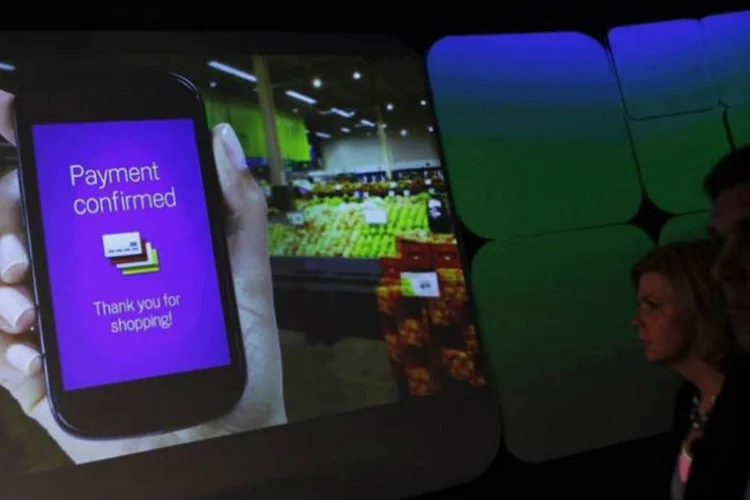 Pessoas veem demonstração do aplicativo Google Wallet (Shannon Stapleton/Reuters)