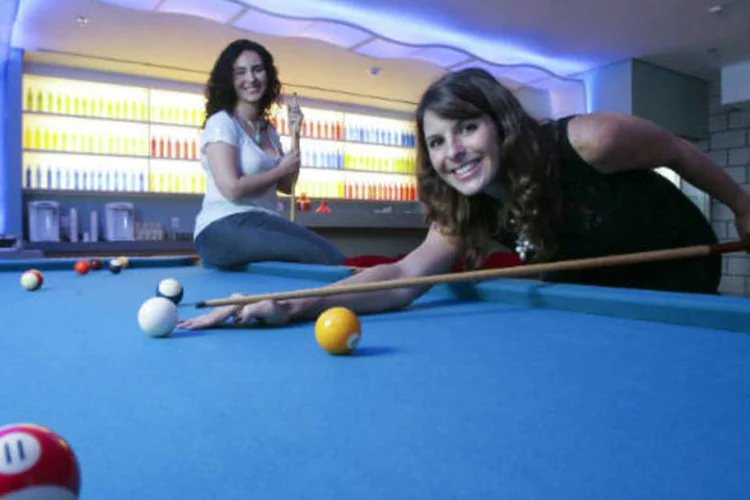 Karina Roque (vestido preto) e Priscila Vieira, funcionárias do Google, jogando bilhar na área de lazer empresa, localizado no edifício Pátio Victor Malzoni, na avenida Faria Lima, em São Paulo (Fernando Moraes/Veja São Paulo)