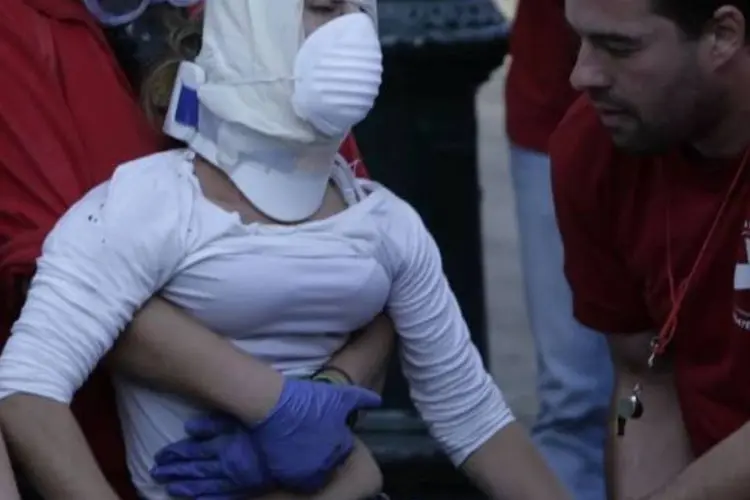 Mulher foi socorrida por paramédicos, durante os protestos (Milos Bicanski/Getty Images)
