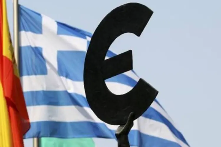 Bandeira grega atrás de uma estátua da unidade europeia do Parlamento Europeu, em Bruxelas: para Fitch, saída da Grécia causará queda imediata de rating de outras nações (Francois Lenoir/Reuters)