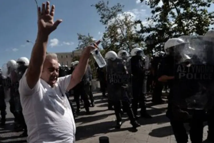 
	Pol&iacute;cia e manifestantes em confronto em Atenas durante protestos: a pol&iacute;cia lan&ccedil;ou bombas de g&aacute;s lacrimog&ecirc;neo para dispersar a multid&atilde;o
 (Aris Messinis/AFP)