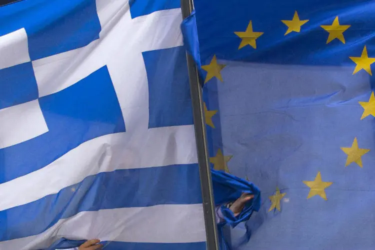 
	Bandeiras da Gr&eacute;cia (D) e da Uni&atilde;o Europeia: empr&eacute;stimo vence nesta semana.
 (Yves Herman/Reuters)