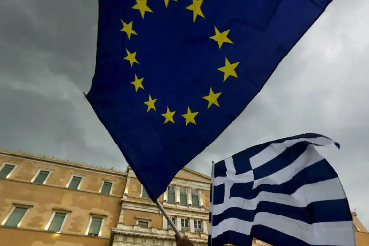
	Manifestante carrega bandeiras da Gr&eacute;cia e da Uni&atilde;o Europeia
 (Yannis Behrakis/Reuters)