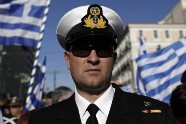 Oficiais e reservistas do exército da Grécia carregam bandeiras em um protesto contra austeridade no centro de Atenas (John Kolesidis/Reuters)