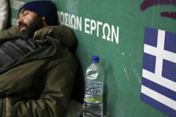 Morador de rua dorme em frente a estação de metrô de Atenas, na Grécia (REUTERS/Yannis Behrakis)